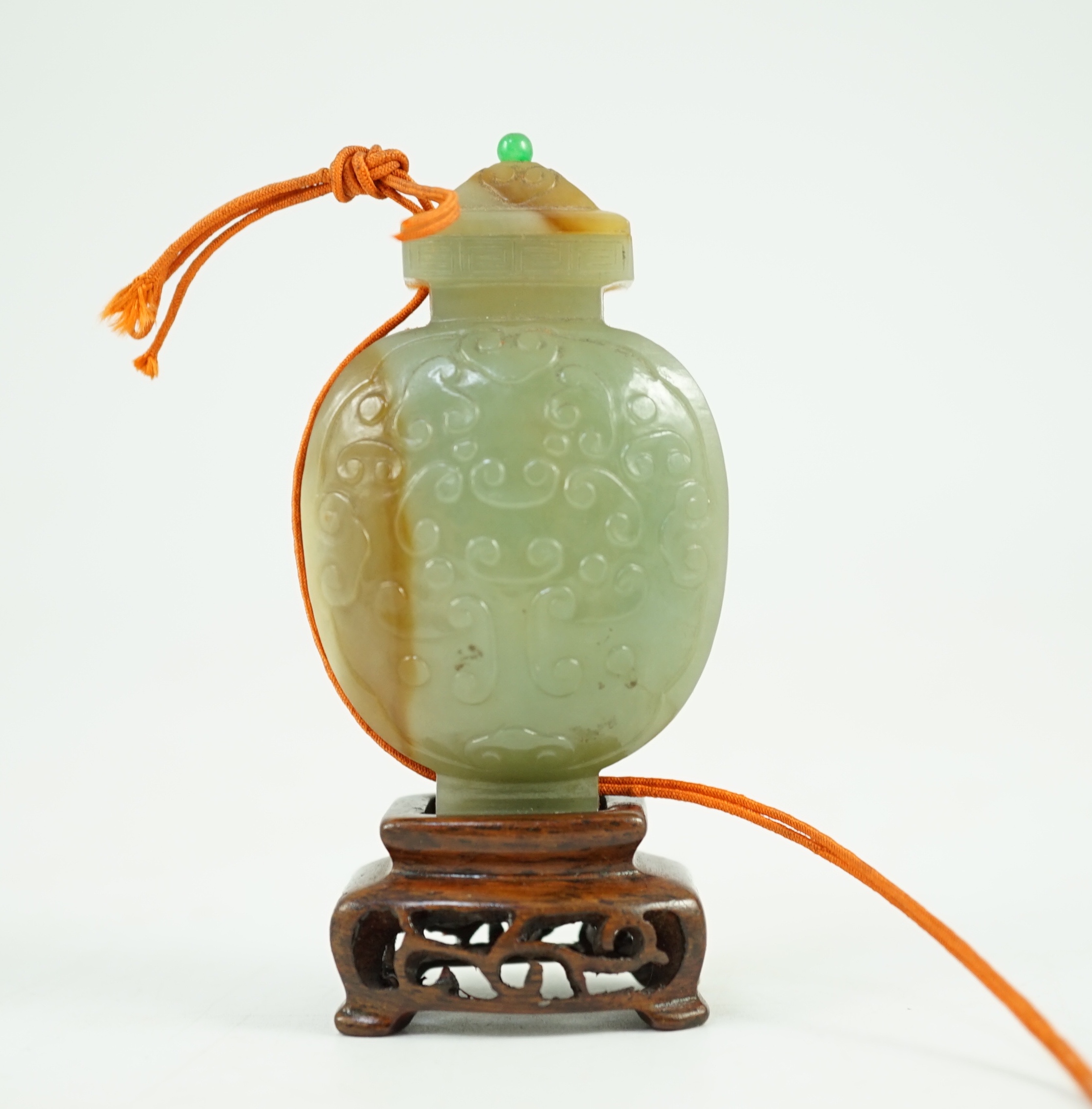 A Chinese archaistic green and russet jade miniature vase and cover, fanghu, 19th century, 6.7 cm high, foot re-carved, wood stand